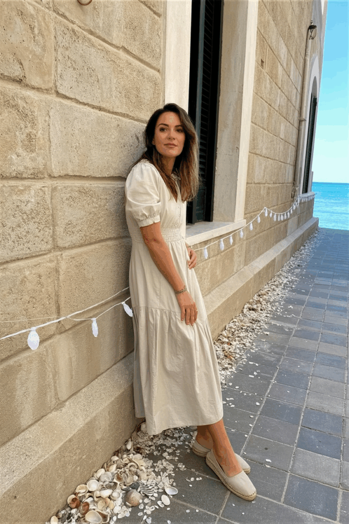 Woman in airy cotton ankle dress and flat espadrilles