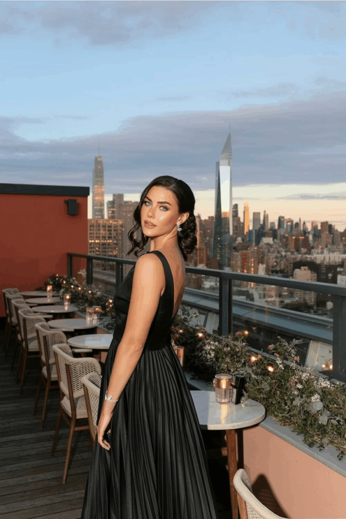 woman in a black tie A-line gown with soft pleats, fitted at the waist