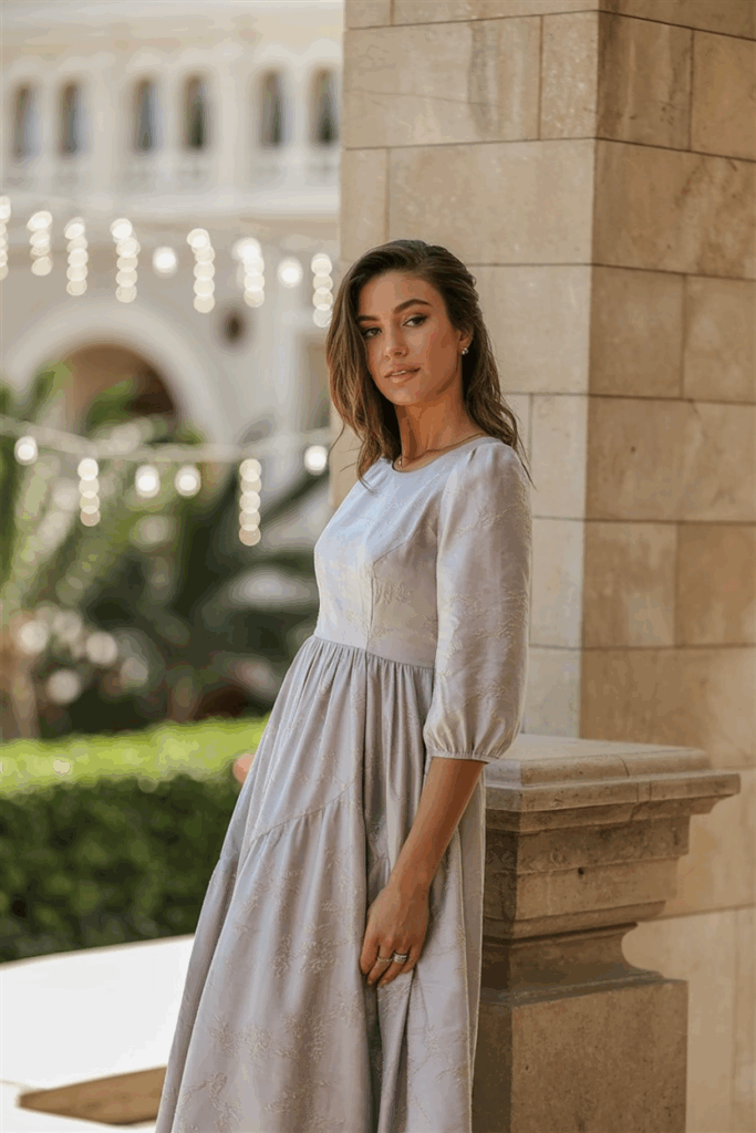 A woman in a soft pastel dress with elegant three-quarter sleeves and an empire waist