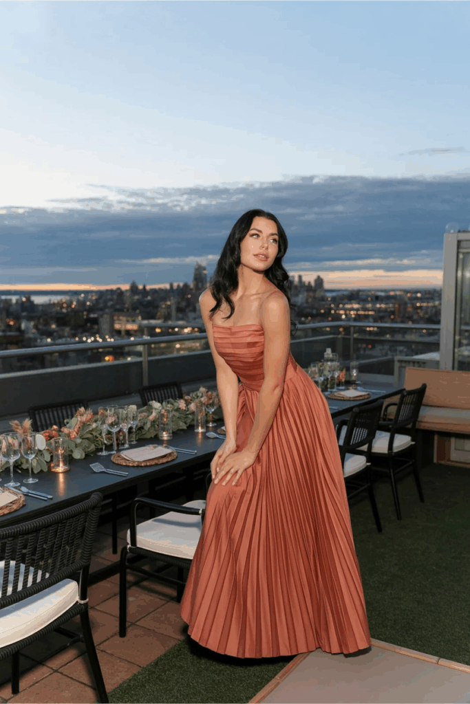 woman in a black tie A-line terracotta gown with soft pleats