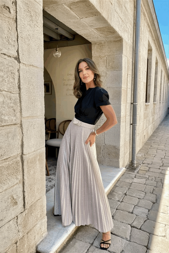 woman in a black tie A-line skirt with soft pleats, fitted at the waist