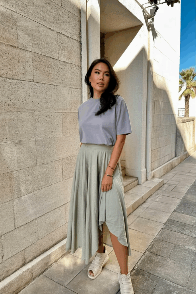 woman wearing a muted pastel midi skirt with an asymmetrical hem