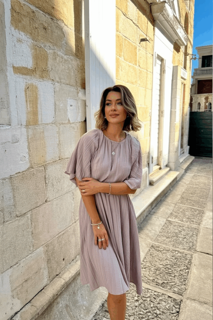 Woman in a dusty rose dress with short flutter sleeves