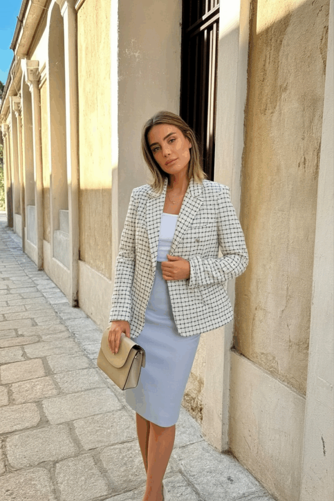 woman wearing a tailored tweed blazer over a pencil skirt