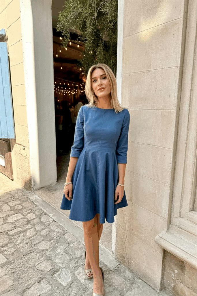 A woman in a beautifully tailored Navy Sky A-line dress with 3/4 sleeves dress with fitted sleeve