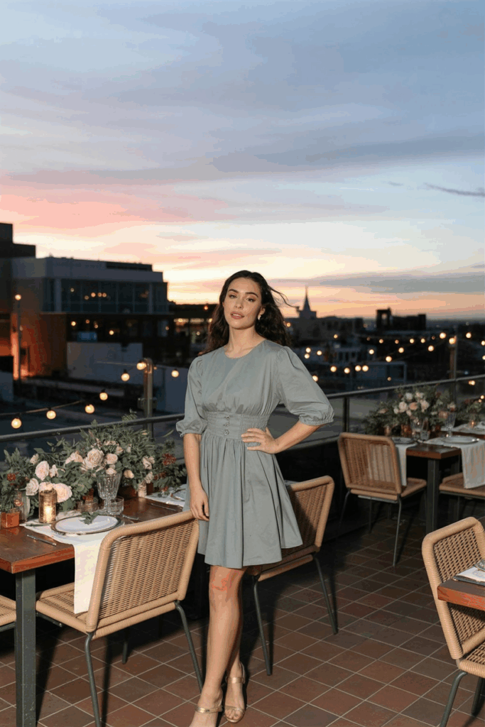 A woman in a soft gray dress with elegant three-quarter sleeves and an empire waist