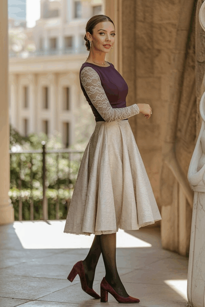 A woman wearing a plum fit-and-flare dress with lace long sleeves, black fleece-lined tights, and burgundy block-heeled pumps