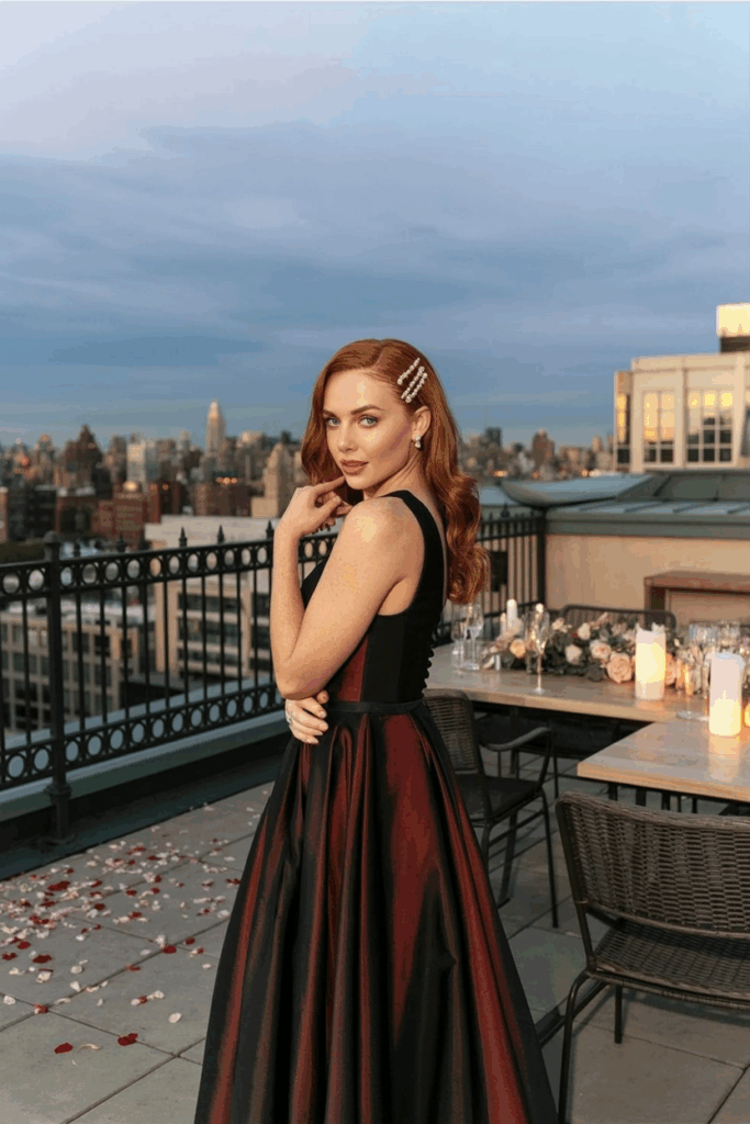 woman in a black tie A-line burgundy gown with soft pleats, fitted at the waist