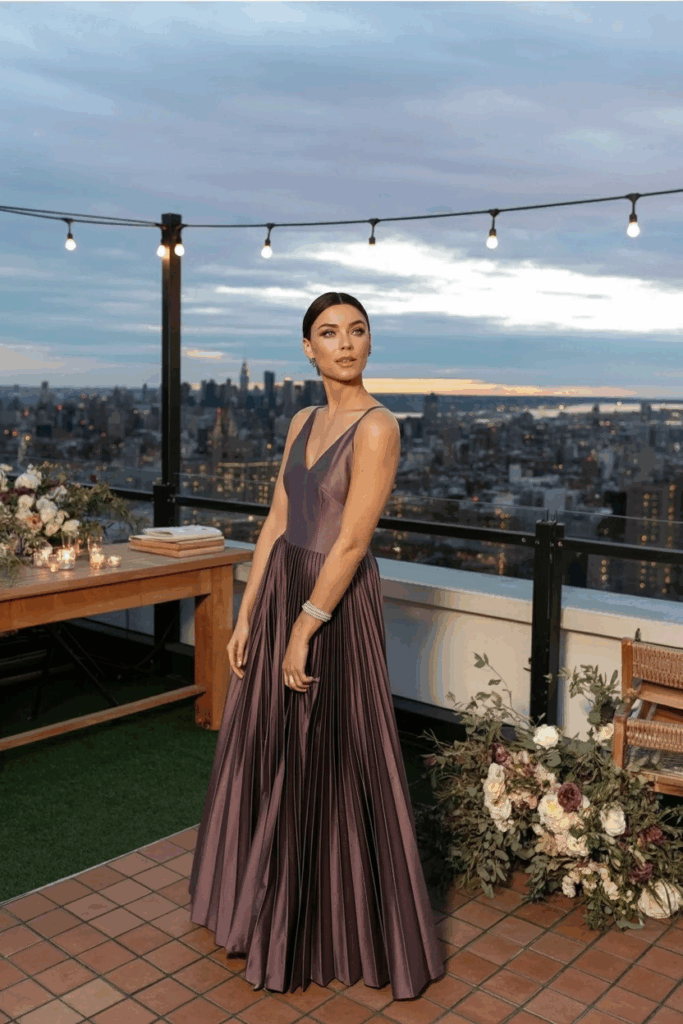 woman in a black tie A-line deep mauve gown with soft pleats