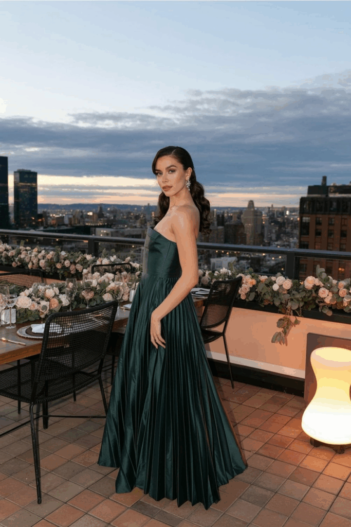 woman in a black tie A-line emerald gown with soft pleats