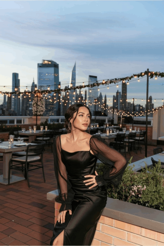 woman in a black tie dress with sheer long sleeves