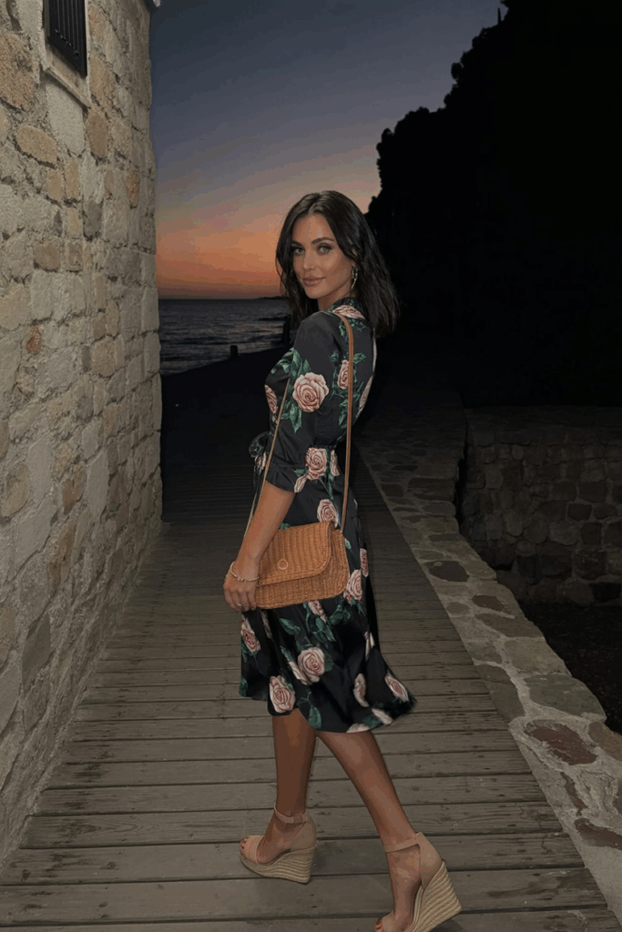 rose-print wrap dress with three-quarter sleeves, nude wedge heels, and a woven crossbody bag