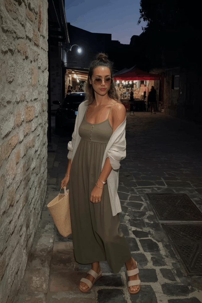 a muted olive cotton maxi dress with an oversized beige cardigan, flat sandals, and large sunglasses