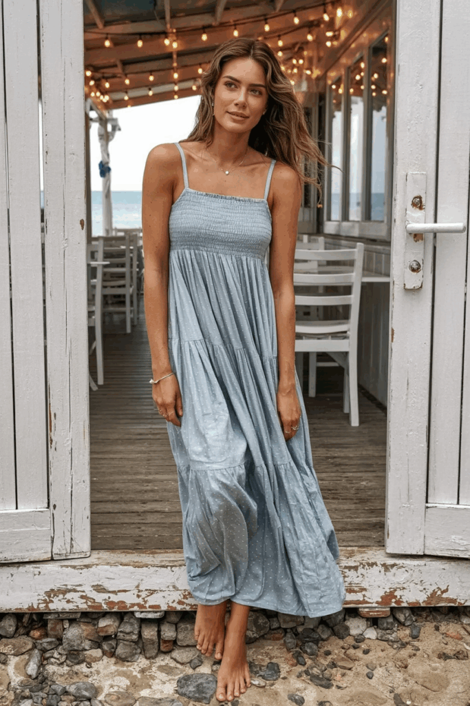 A woman in a soft pastel blue cotton sundress with thin straps and a skirt