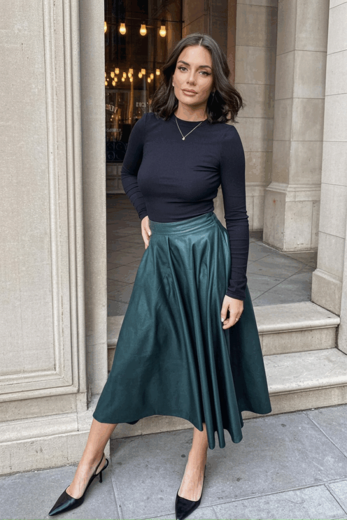 A woman wearing a fitted jersey long-sleeve top and flowy midi skirt with slingbacks
