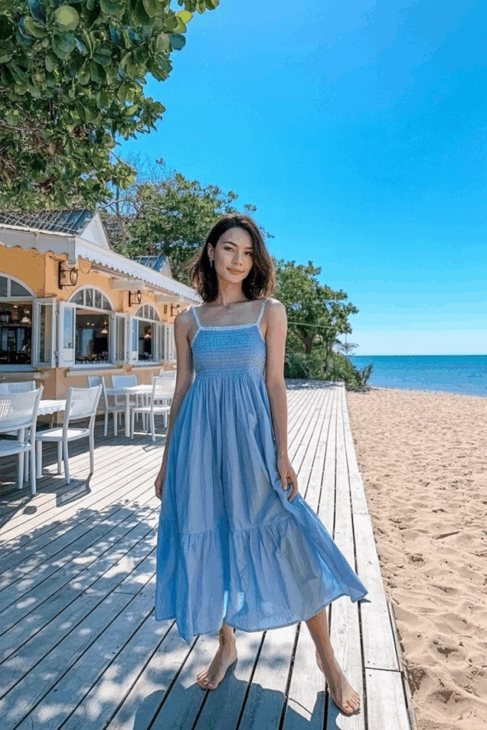 A woman in a soft pastel blue cotton sundress with thin straps and a skirt