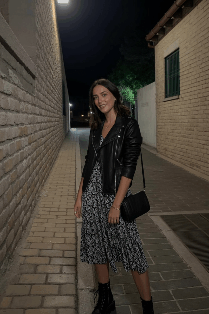 black leather jacket over a flowy floral midi dress, lace-up boots, and a crossbody bag