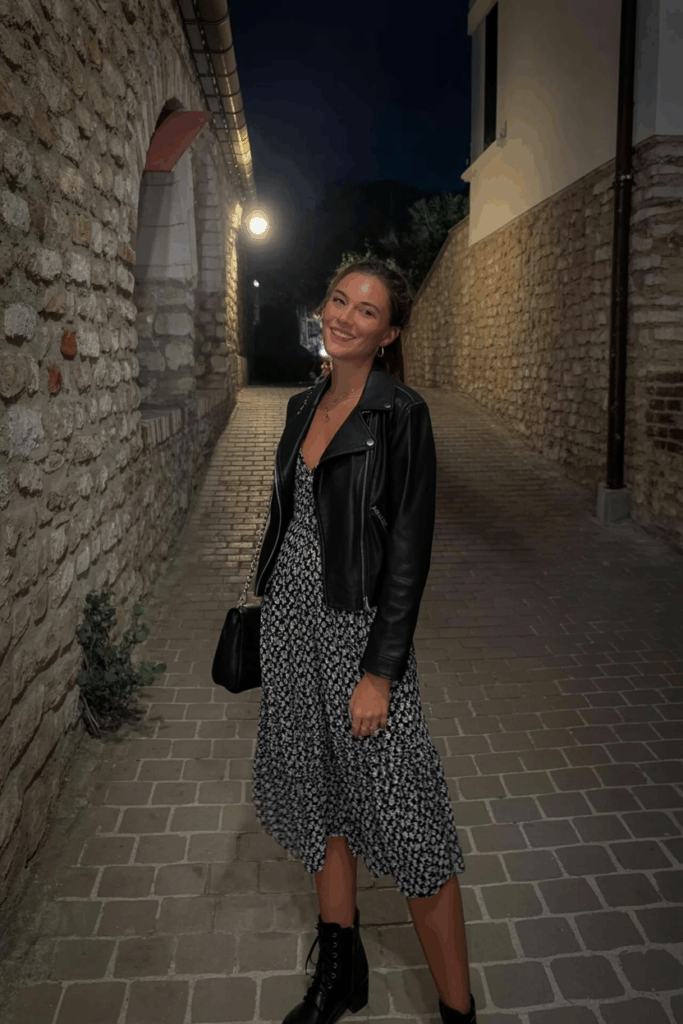 black leather jacket over a flowy floral midi dress, lace-up boots, and a crossbody bag