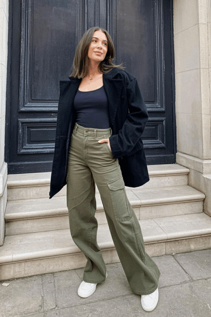 olive green straight-leg cargo pants, a fitted black tank top, and minimalist white sneaker