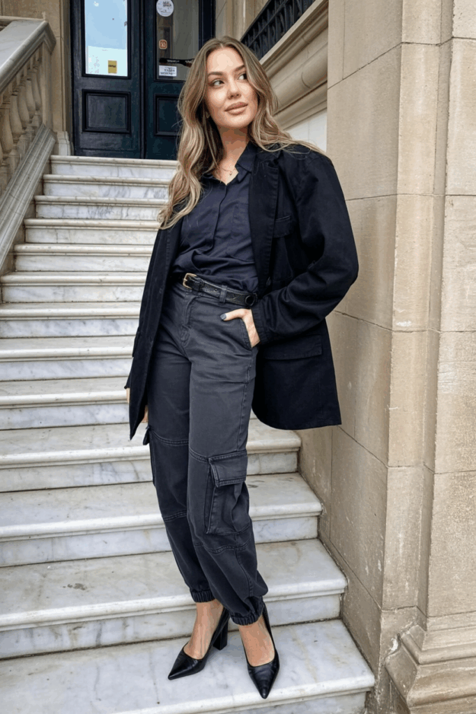 black cargo pants, a blush pink fitted blazer, a tucked silk cami, and pointed-toe mules